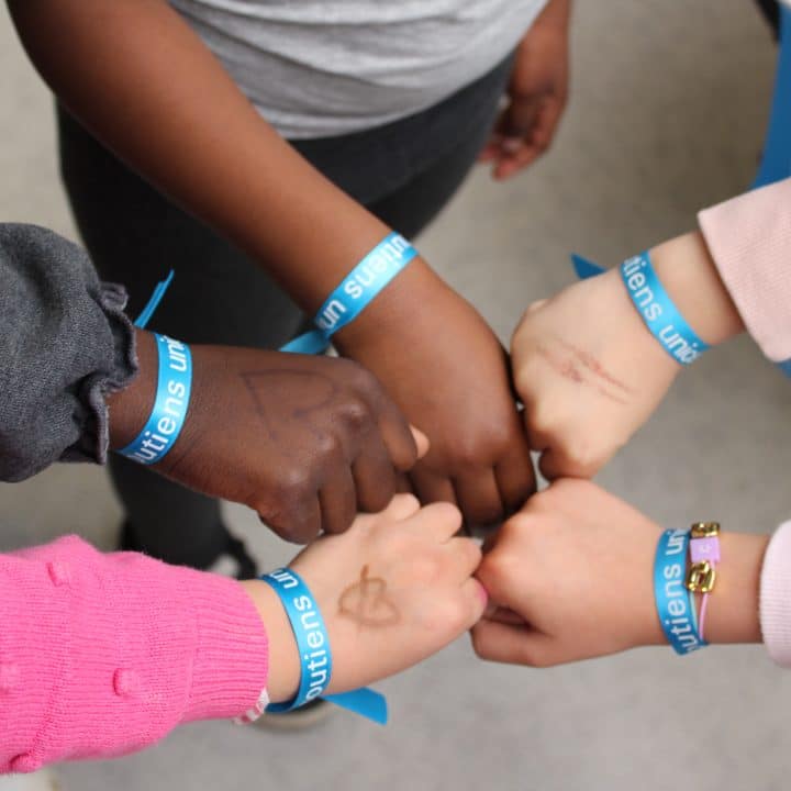 Mains d'enfant avec le bracelet UNICEF